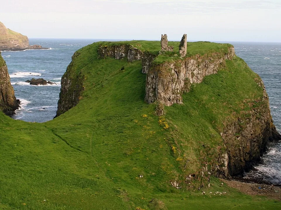 Ruins of Dunseverick Castle on a green headland above the Atlantic